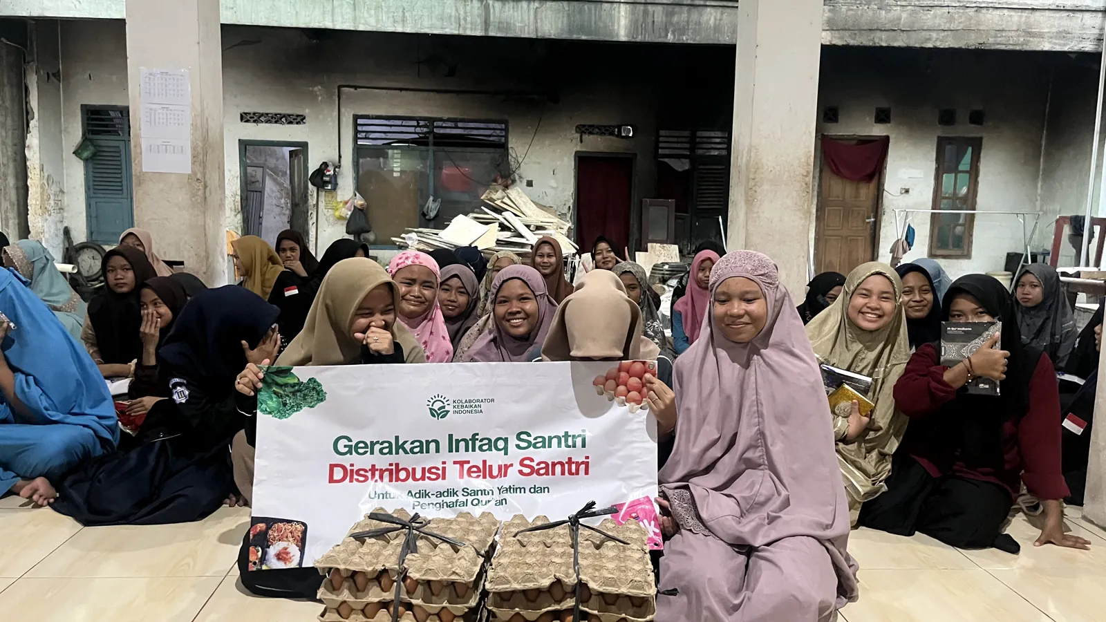 Para santri bersama bantuan telur dan banner kegiatan